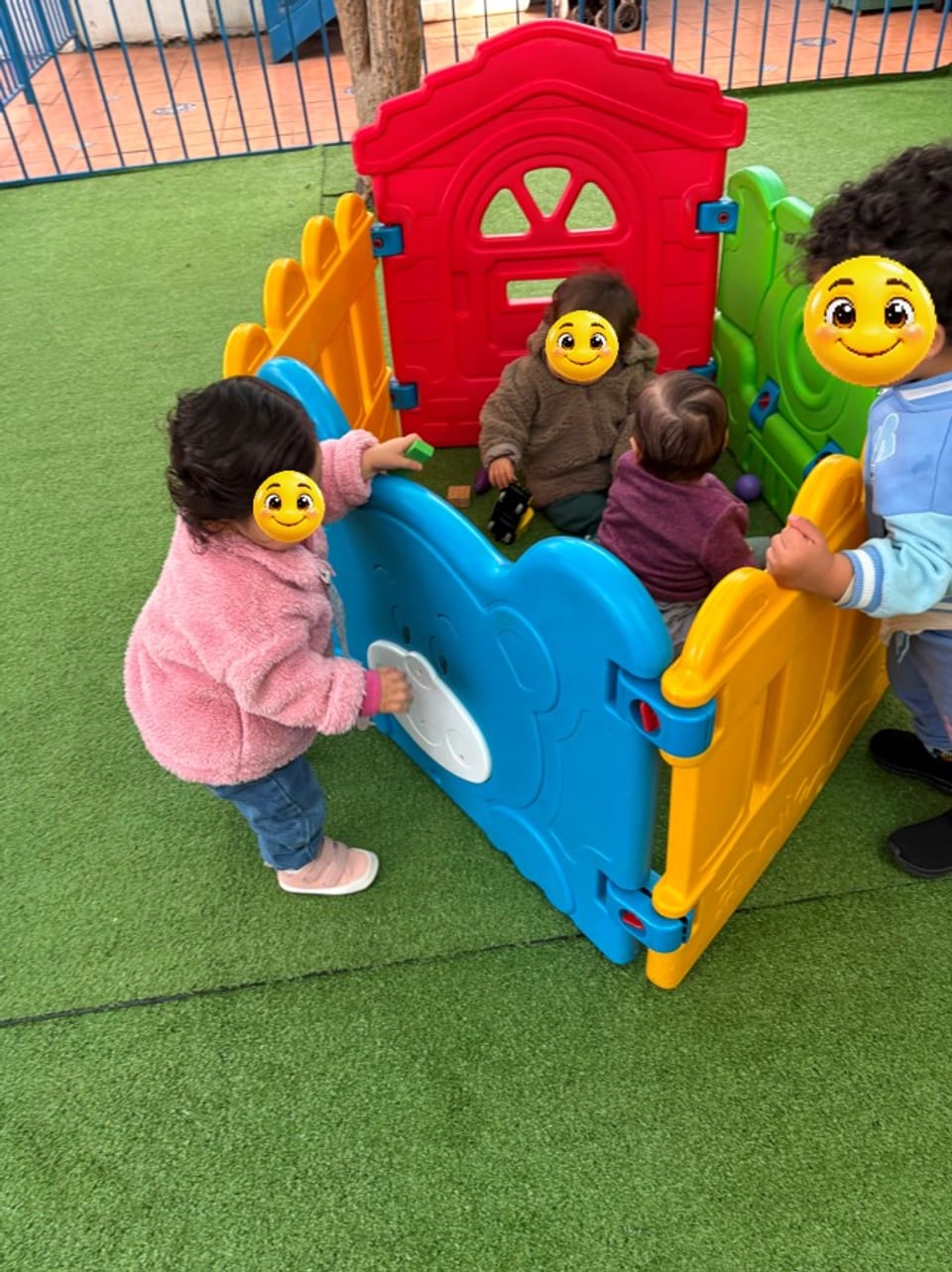 Niños y niñas jugando en una casita de patio